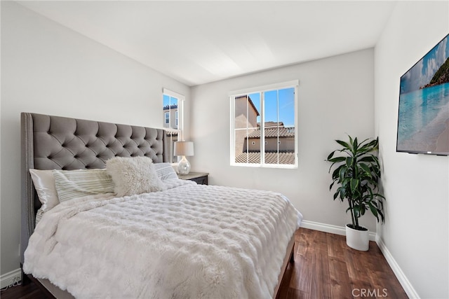 bedroom with wood finished floors and baseboards