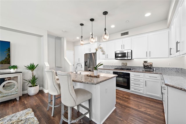 kitchen featuring black appliances, light stone counters, a sink, and visible vents