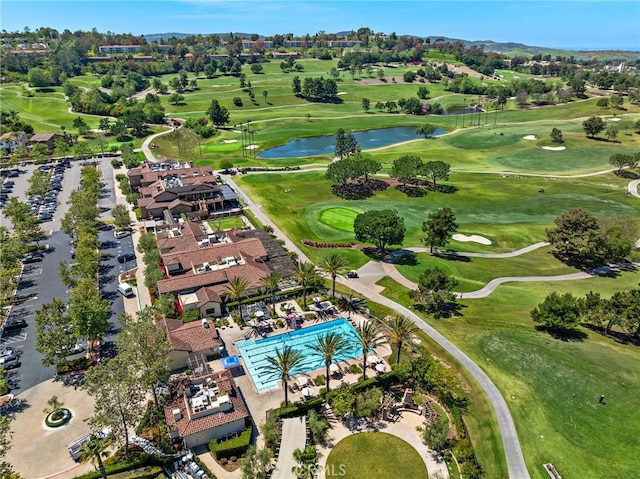 drone / aerial view featuring golf course view and a water view