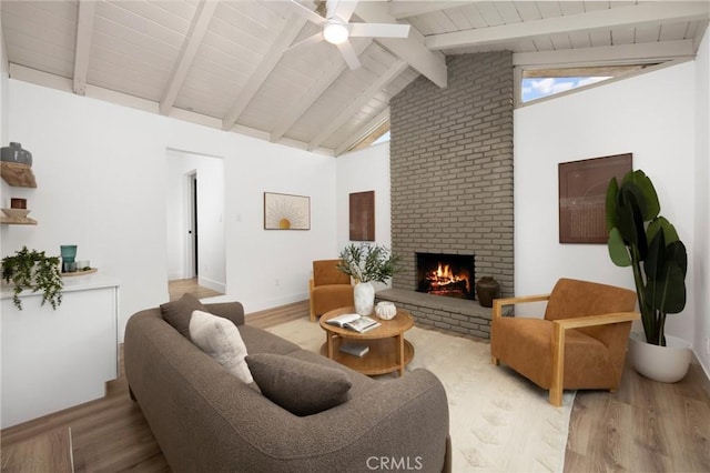 living room with wood finished floors, a brick fireplace, and ceiling fan