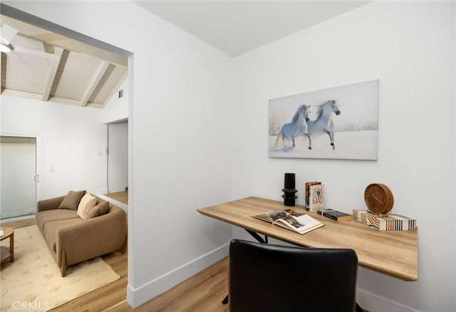 office featuring ceiling fan, baseboards, wood finished floors, and vaulted ceiling with beams