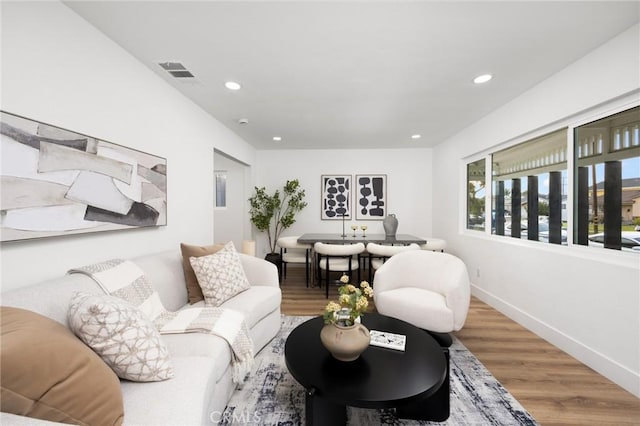 living room featuring recessed lighting, wood finished floors, and visible vents