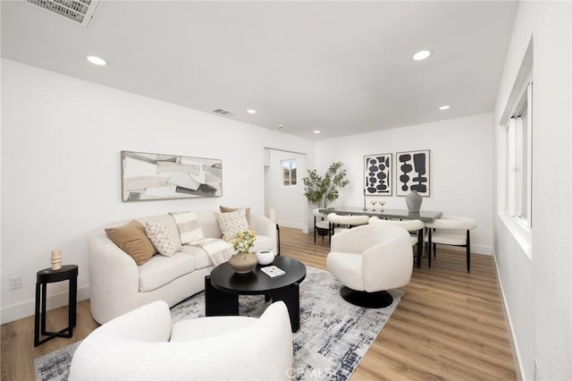 living area featuring light wood finished floors, baseboards, recessed lighting, and visible vents