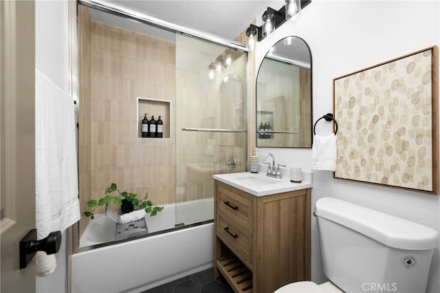 bathroom featuring tile patterned floors, enclosed tub / shower combo, toilet, and vanity