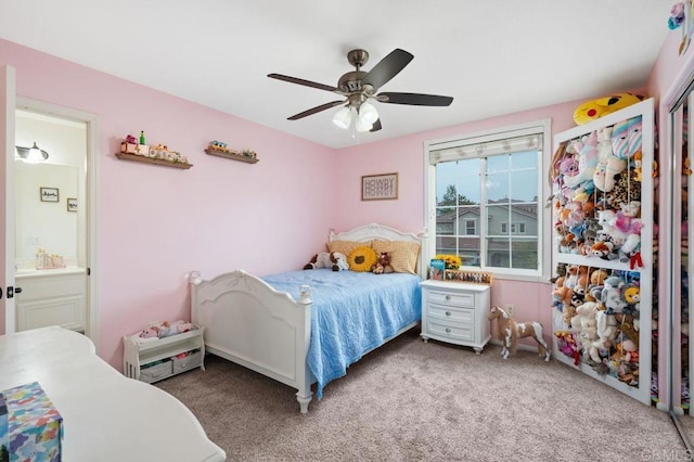 carpeted bedroom featuring a ceiling fan and ensuite bath