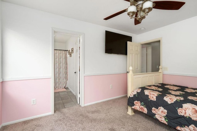 carpeted bedroom featuring baseboards, ensuite bath, and ceiling fan