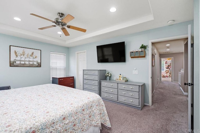 bedroom featuring recessed lighting, a tray ceiling, carpet floors, baseboards, and ceiling fan