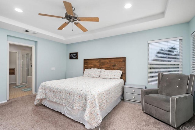 carpeted bedroom featuring a tray ceiling, visible vents, and recessed lighting