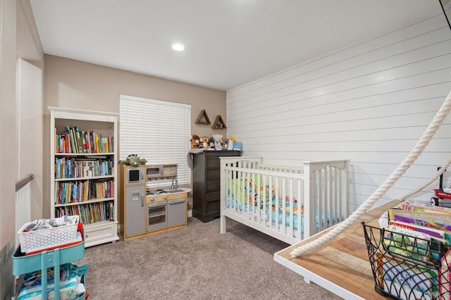 carpeted bedroom featuring wooden walls and recessed lighting