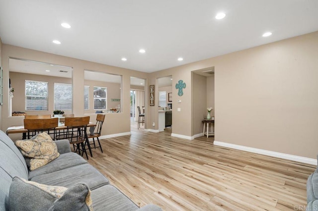 living room with recessed lighting, light wood-style flooring, and baseboards