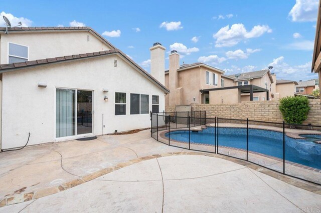 view of pool featuring a fenced backyard, a patio, and a pool with connected hot tub