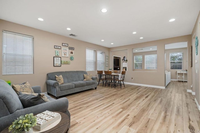 living room with light wood-style floors, recessed lighting, and baseboards