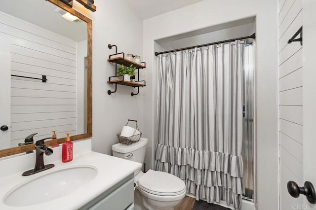bathroom with curtained shower, toilet, and vanity