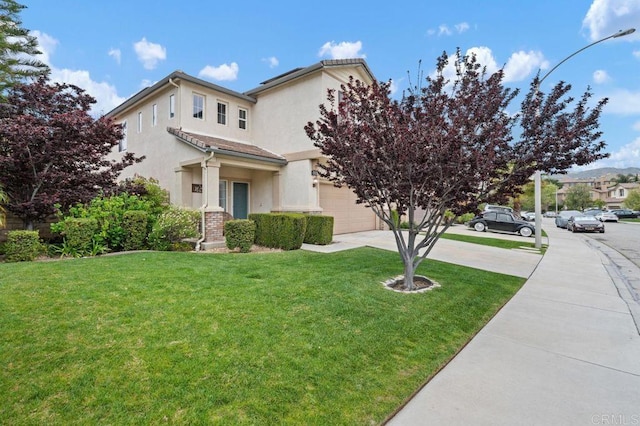 view of front of house featuring stucco siding, driveway, and a front yard