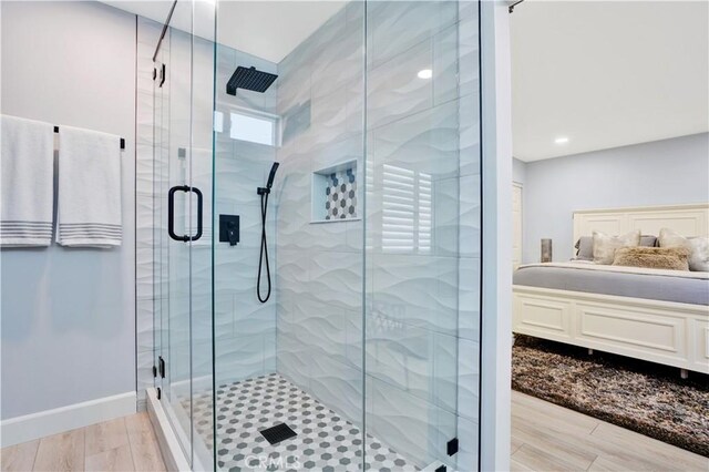 bathroom with a shower stall, baseboards, and wood finished floors