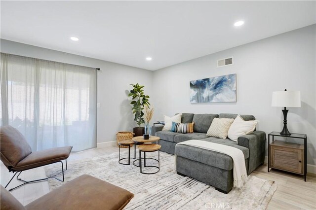 living room with recessed lighting, baseboards, visible vents, and light wood-style flooring