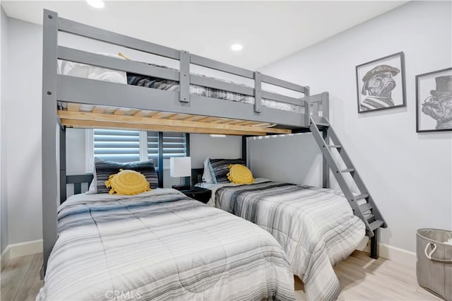 bedroom featuring wood finished floors, baseboards, and recessed lighting