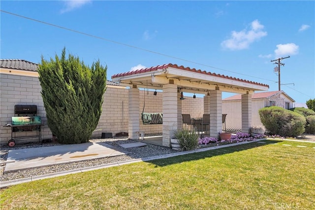 back of property featuring a tiled roof, a yard, and a patio