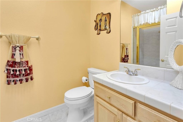 bathroom with vanity, marble finish floor, walk in shower, baseboards, and toilet