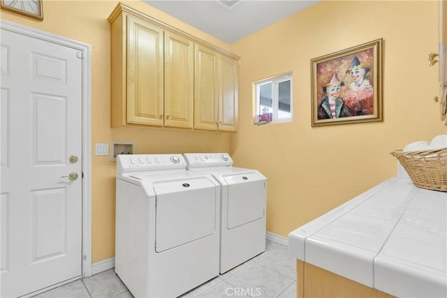 laundry area with washing machine and clothes dryer, cabinet space, and baseboards