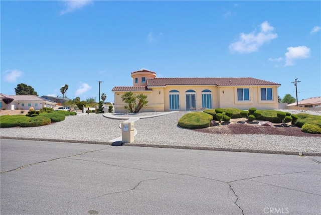 mediterranean / spanish-style house with a tile roof and stucco siding