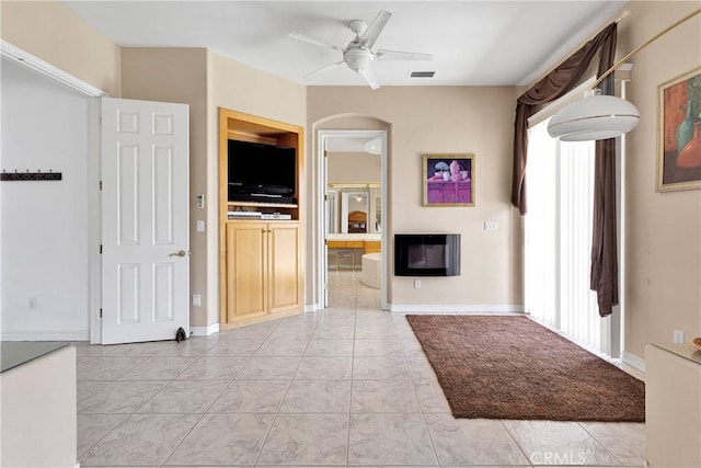 interior space featuring visible vents, baseboards, arched walkways, and ceiling fan