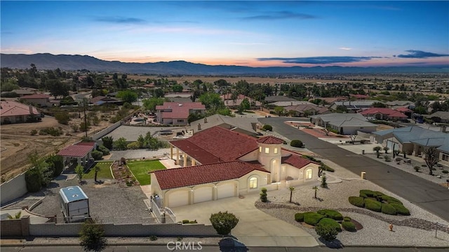 aerial view at dusk featuring a residential view and a mountain view