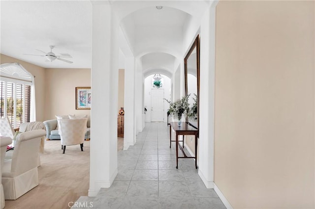hallway with arched walkways and baseboards