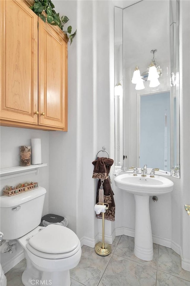 bathroom featuring baseboards, marble finish floor, and toilet