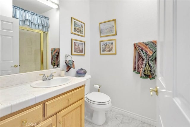 bathroom with marble finish floor, toilet, vanity, baseboards, and walk in shower