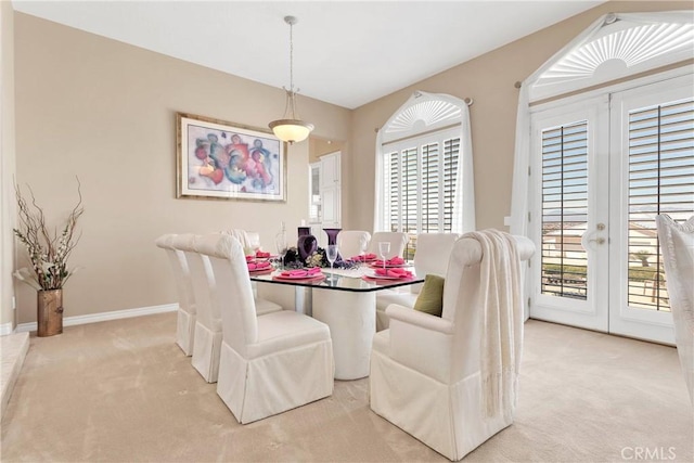 dining area featuring baseboards and light colored carpet