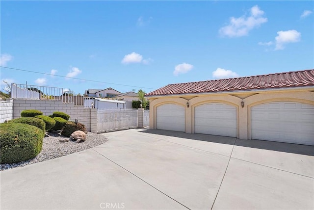 garage featuring fence and a gate