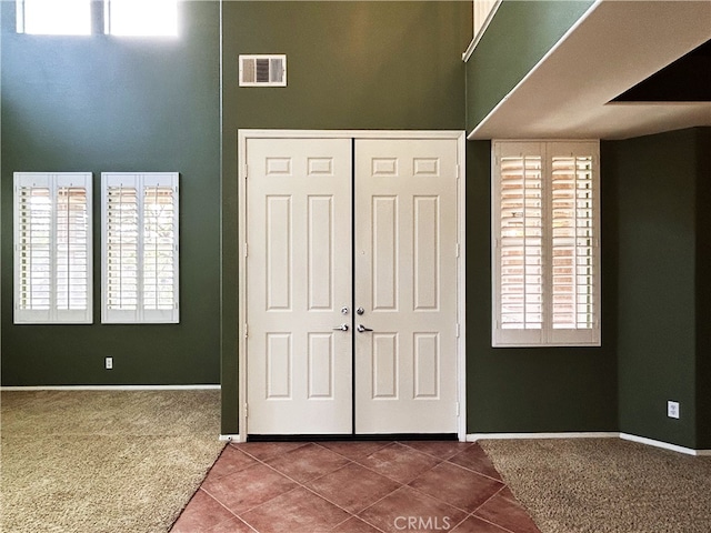 5743 Kendall Ct, Rancho Cucamonga, CA 91739 - carpeted foyer entrance with tile patterned floors, baseboards, a high ceiling, and healthy amount of natural light