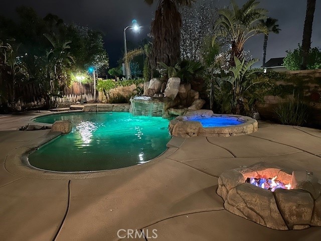 5743 Kendall Ct, Rancho Cucamonga, CA 91739 - pool at night with a patio and a pool with connected hot tub