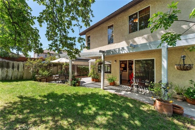 19852 Pandy Ct, Canyon Country, CA 91351 - back of property with a patio area, a lawn, stucco siding, and fence