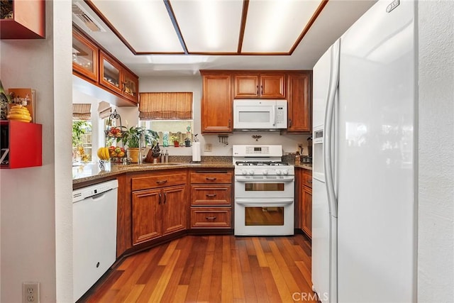 19852 Pandy Ct, Canyon Country, CA 91351 - kitchen with brown cabinets, light stone counters, a sink, dark wood-type flooring, and white appliances