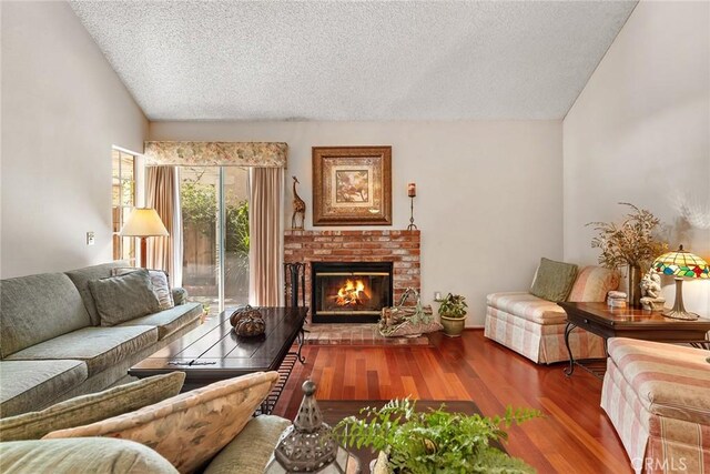 19852 Pandy Ct, Canyon Country, CA 91351 - living area with lofted ceiling, a brick fireplace, wood finished floors, and a textured ceiling