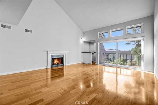 18324 Clark St Unit 315, Tarzana, CA 91356 - unfurnished living room with high vaulted ceiling, a high end fireplace, wood finished floors, and visible vents