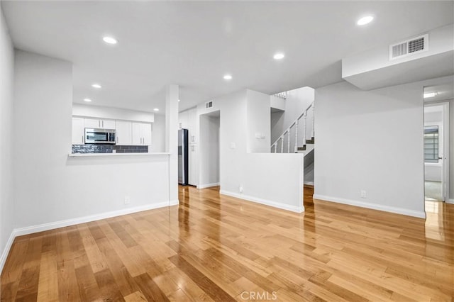 18324 Clark St Unit 315, Tarzana, CA 91356 - unfurnished living room with recessed lighting, light wood-style flooring, visible vents, and baseboards