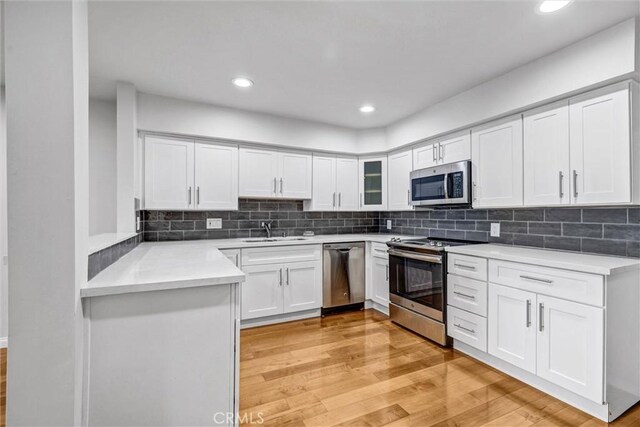 18324 Clark St Unit 315, Tarzana, CA 91356 - kitchen featuring white cabinets, stainless steel appliances, light wood-style flooring, and a sink