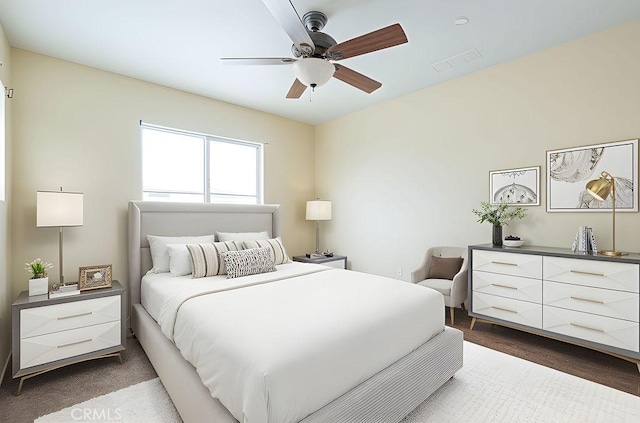 bedroom with a ceiling fan, visible vents, and dark wood-style floors