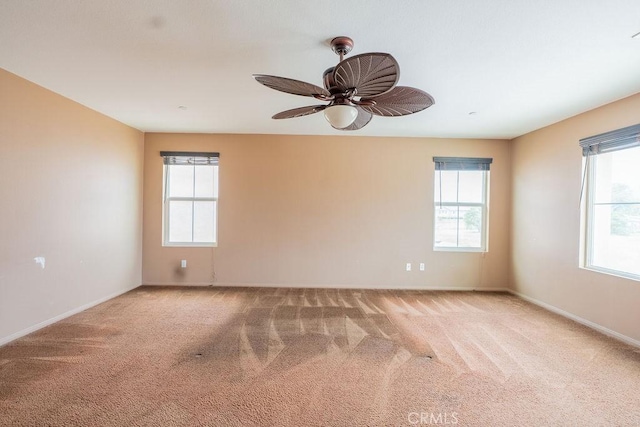 unfurnished room with baseboards, a healthy amount of sunlight, and carpet