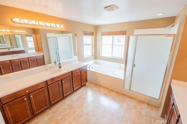 bathroom with tile patterned floors, a sink, a bath, two vanities, and a stall shower