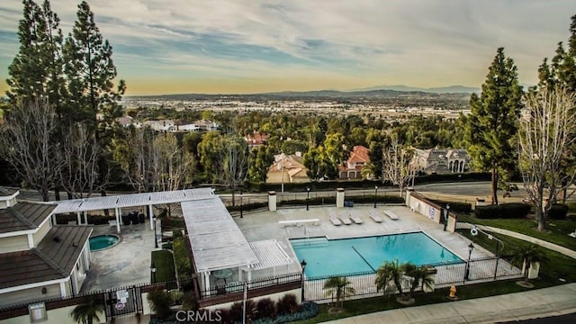 4738 E Fairfield St, Anaheim Hills, CA 92807 - pool at dusk featuring fence, a patio, a community pool, and a mountain view