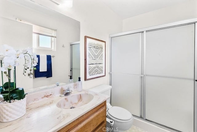bathroom with vanity, toilet, and a stall shower