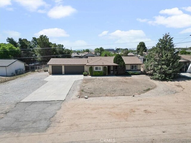 single story home featuring concrete driveway, an attached garage, and fence