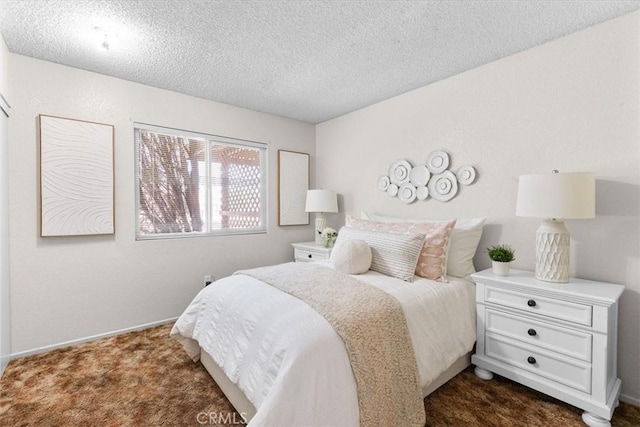 bedroom with dark colored carpet, a textured ceiling, and baseboards