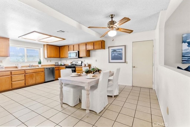 dining space featuring light tile patterned flooring, a textured ceiling, a ceiling fan, and visible vents