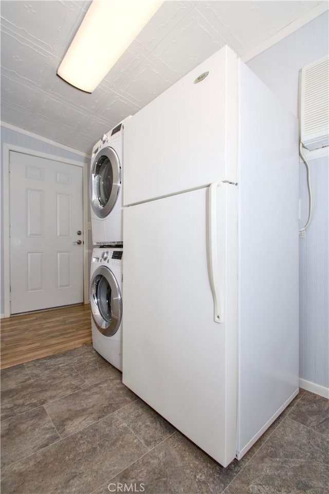 59460 Applegate Way, Landers, CA 92285 - washroom featuring baseboards, stacked washer and clothes dryer, and laundry area