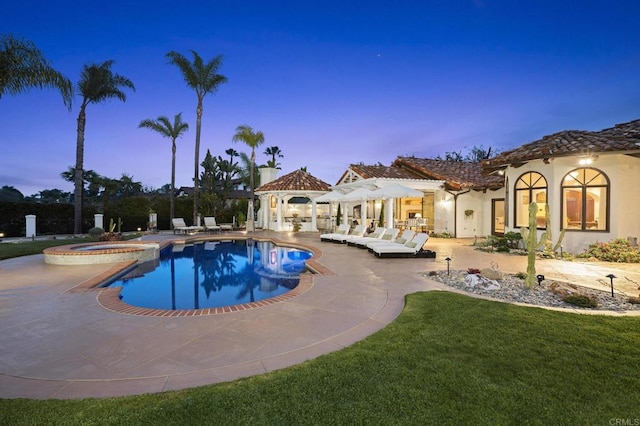 5955 Lake Vista Dr, Bonsall, CA 92003 - pool at dusk featuring a gazebo, a patio area, a lawn, and a pool with connected hot tub